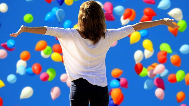Eine Frau freut sich und badet in Luftballons.