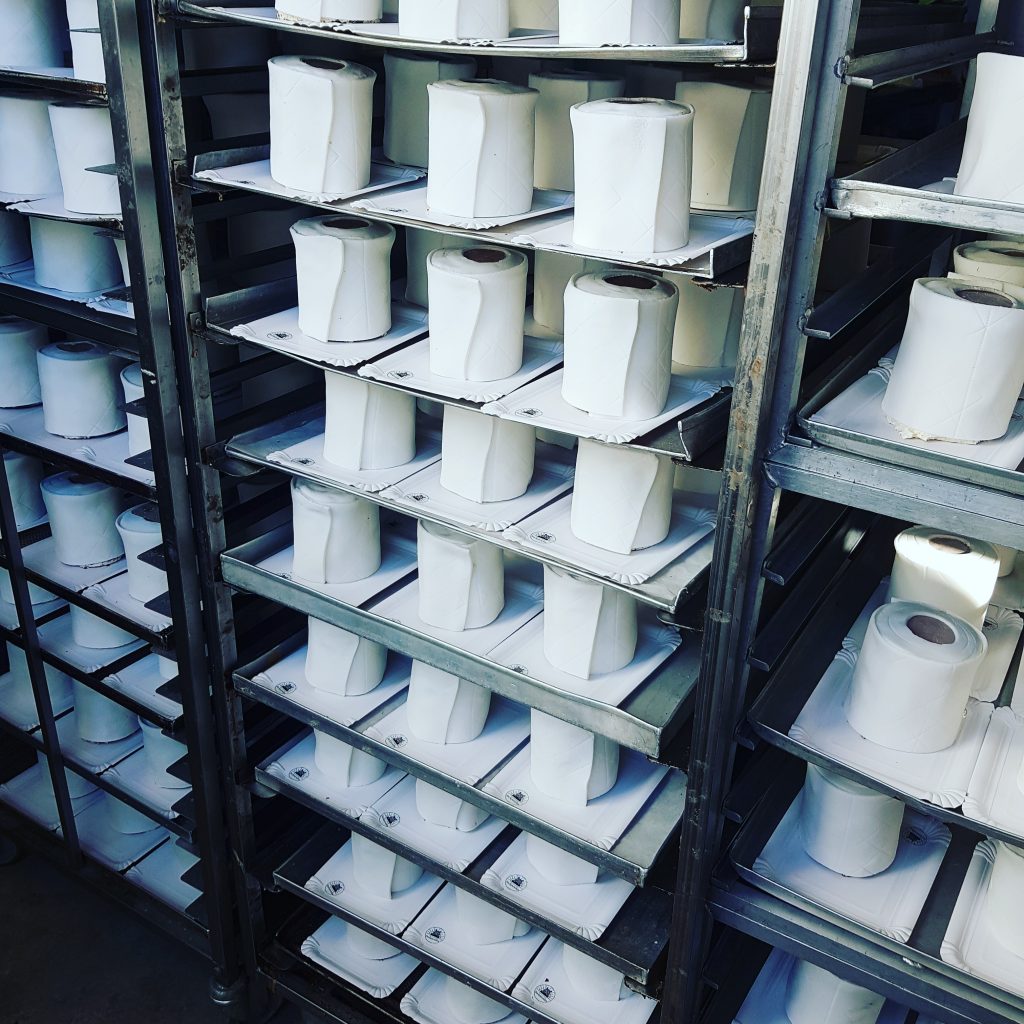 Auf den Backblechen in der Bäckerei stehen Toilettenpapier-Törtchen
