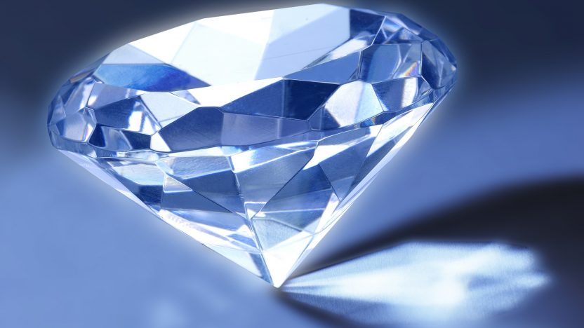 Ein blauer Diamant spiegelt sich im blauen Licht.