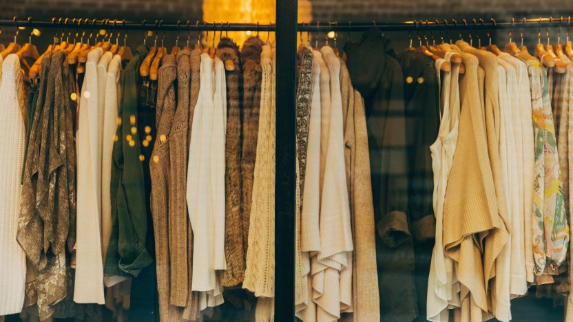 Nachhaltige Entwicklung: Verschiedene Textilien wie Pullover, Hemden oder Jacken für Frauen hängen an einem Schaufenster.