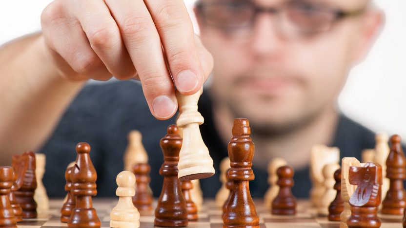 Ein Mann spielt das strategische Brettspiel Schach